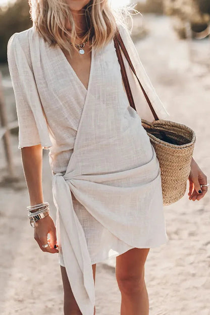 Victoria women's blend wrap mini dress in beige, front view on model at the beach