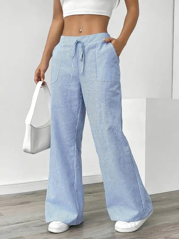 Blue Boho Beach Flare Trousers front view styled with white shoulder handbag