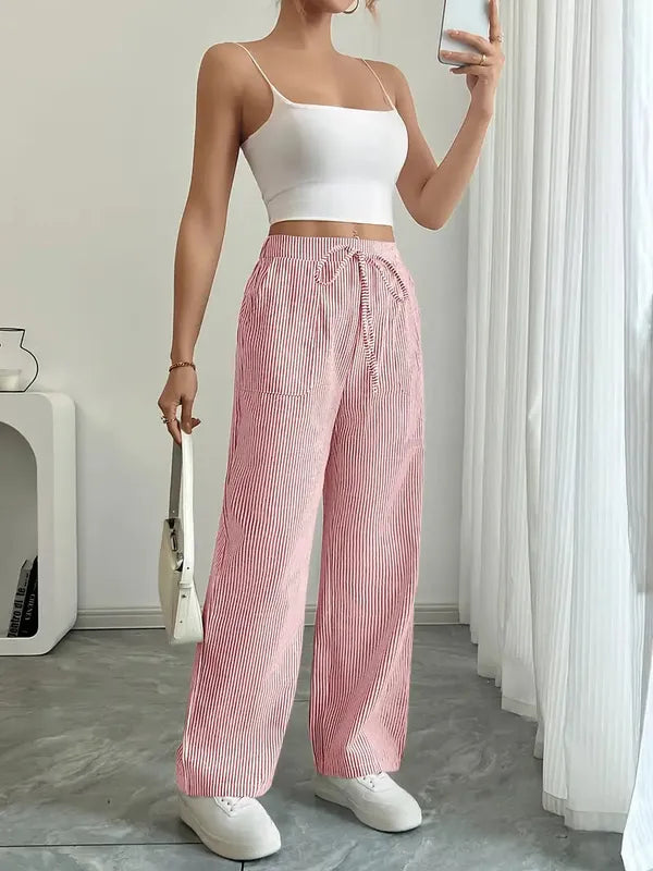 Pink Boho Beach Flare Trousers full front view with white crop top and sneakers