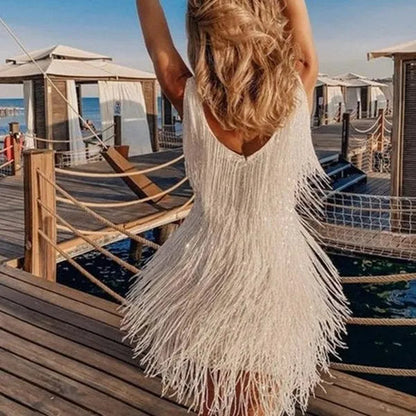 Back view of the white fringe Rosalind cocktail mini dress worn on a wooden pier