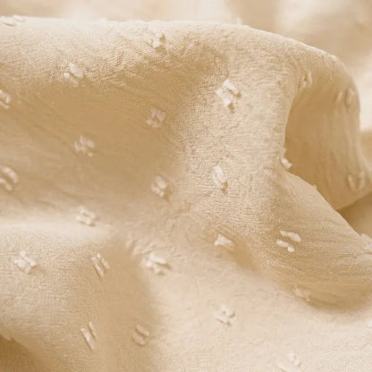 Close-up of the beige swiss dot fabric used in the Abigail mini dress