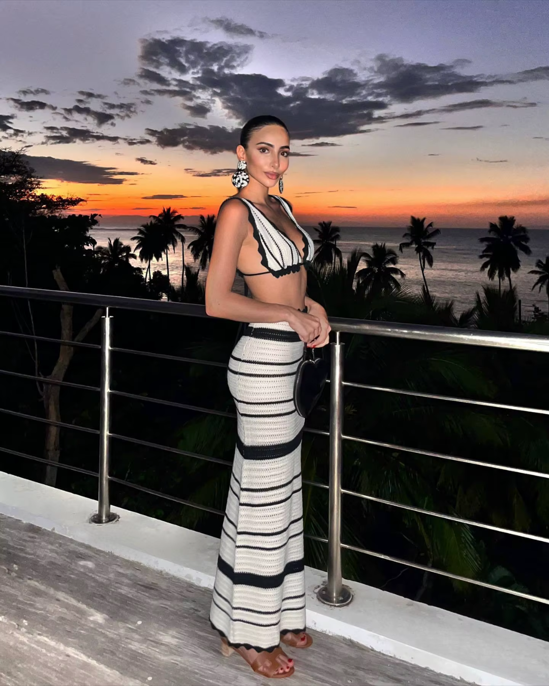 Women's Crochet Sleeveless Maxi Dress in Black, side view on a terrace - Rosamund