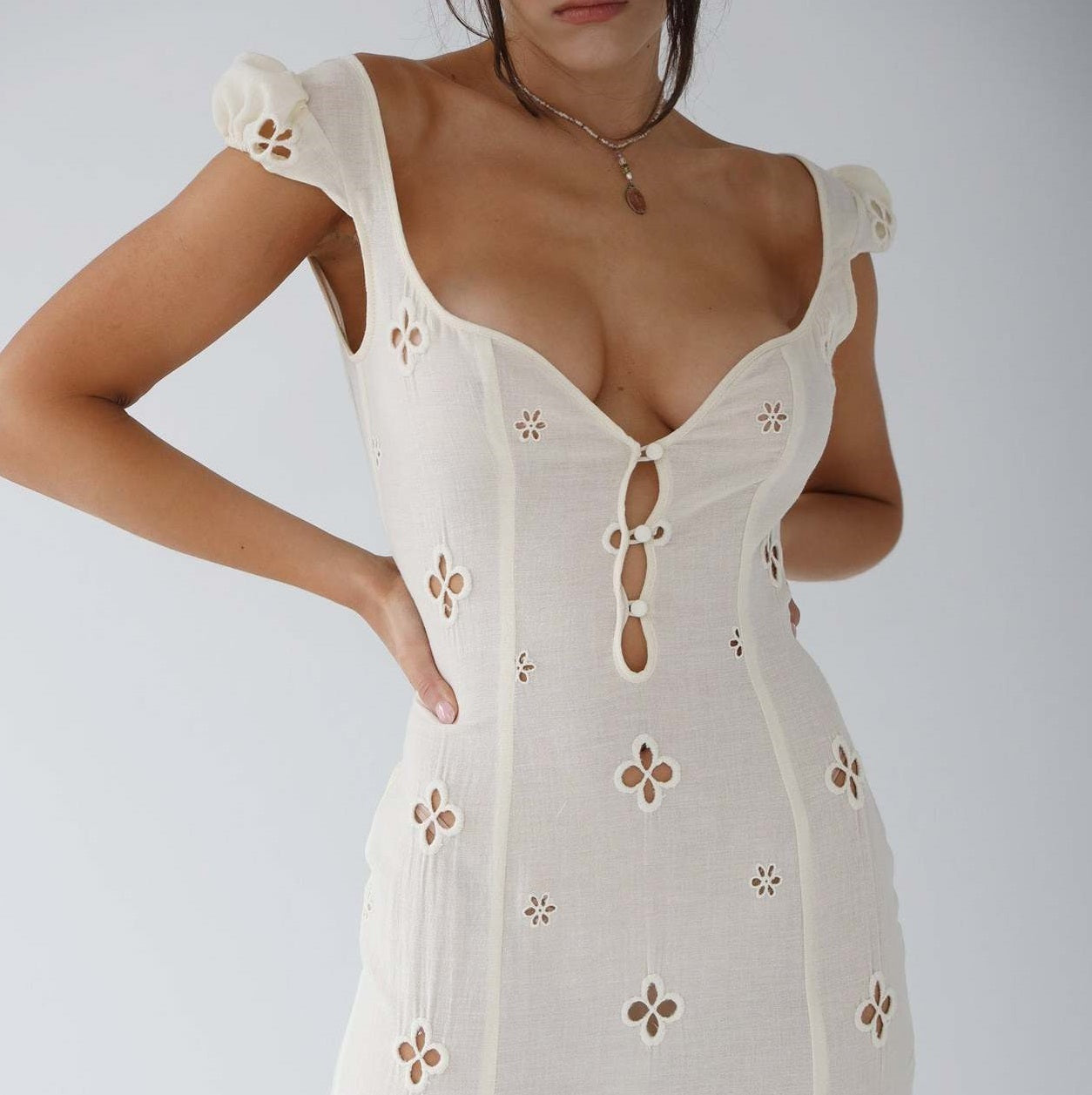 Close-up of the white Adelina cut-out fitted midi dress bodice and eyelet detail