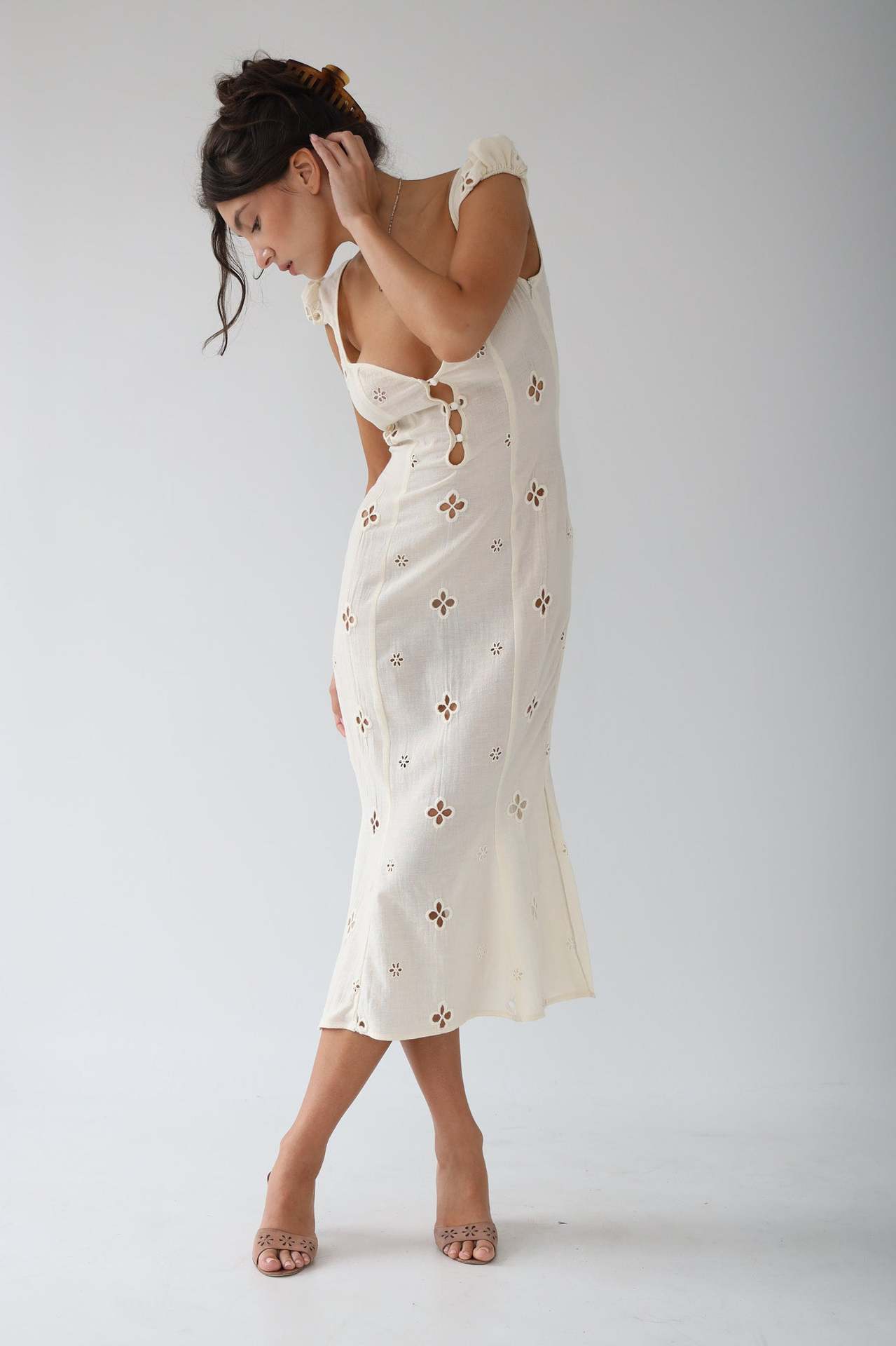 Side view of the Adelina white cut-out fitted midi dress with fluted hem