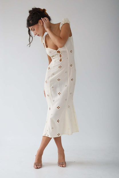 Side view of the Adelina white cut-out fitted midi dress with fluted hem