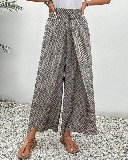 Lucie Women's Smocked Waist Palazzo Trousers in black floral, front view of split hem