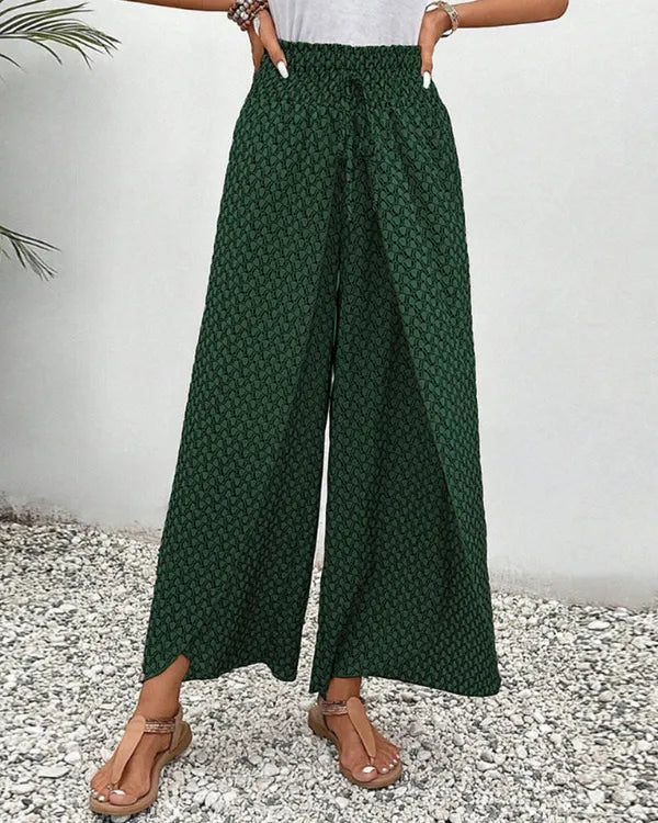 Lucie Women's Smocked Waist Palazzo Trousers in green floral, front view of split hem