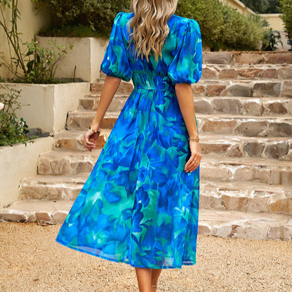 Back view of the blue Lykke floral V-neck midi dress with flowing skirt