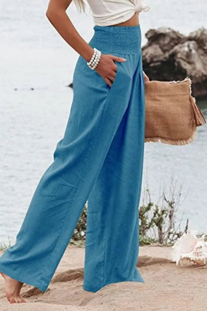 Bethany Women's Flowy Palazzo Trousers in blue, side view on model at beach