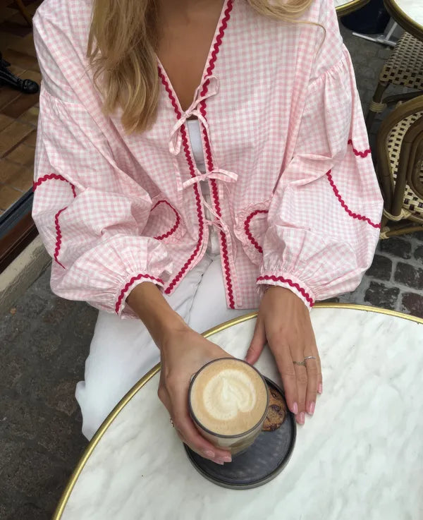 Women's Gingham Heart Print Tie Front Blouse in Pink, front view at a cafe – Cressida