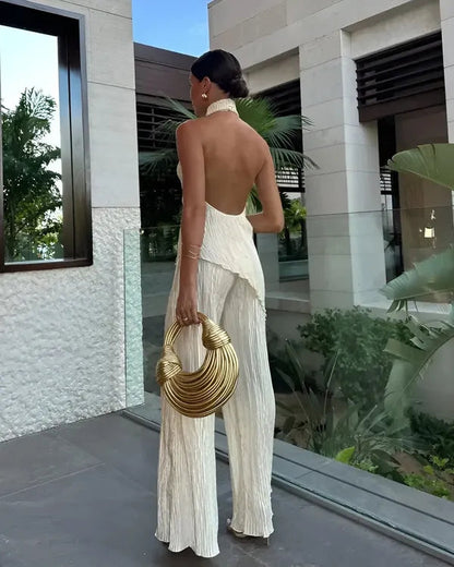 Beige Aira women's halter backless plisse jumpsuit, open back view on model