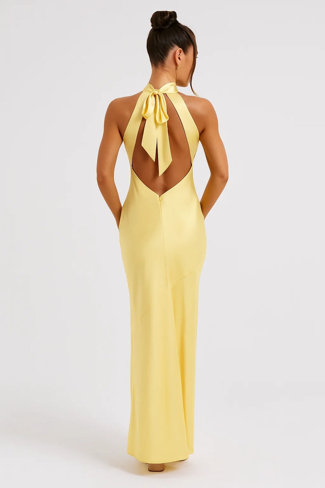 Almodis yellow halter neck maxi dress from behind, open back with bow tie detail