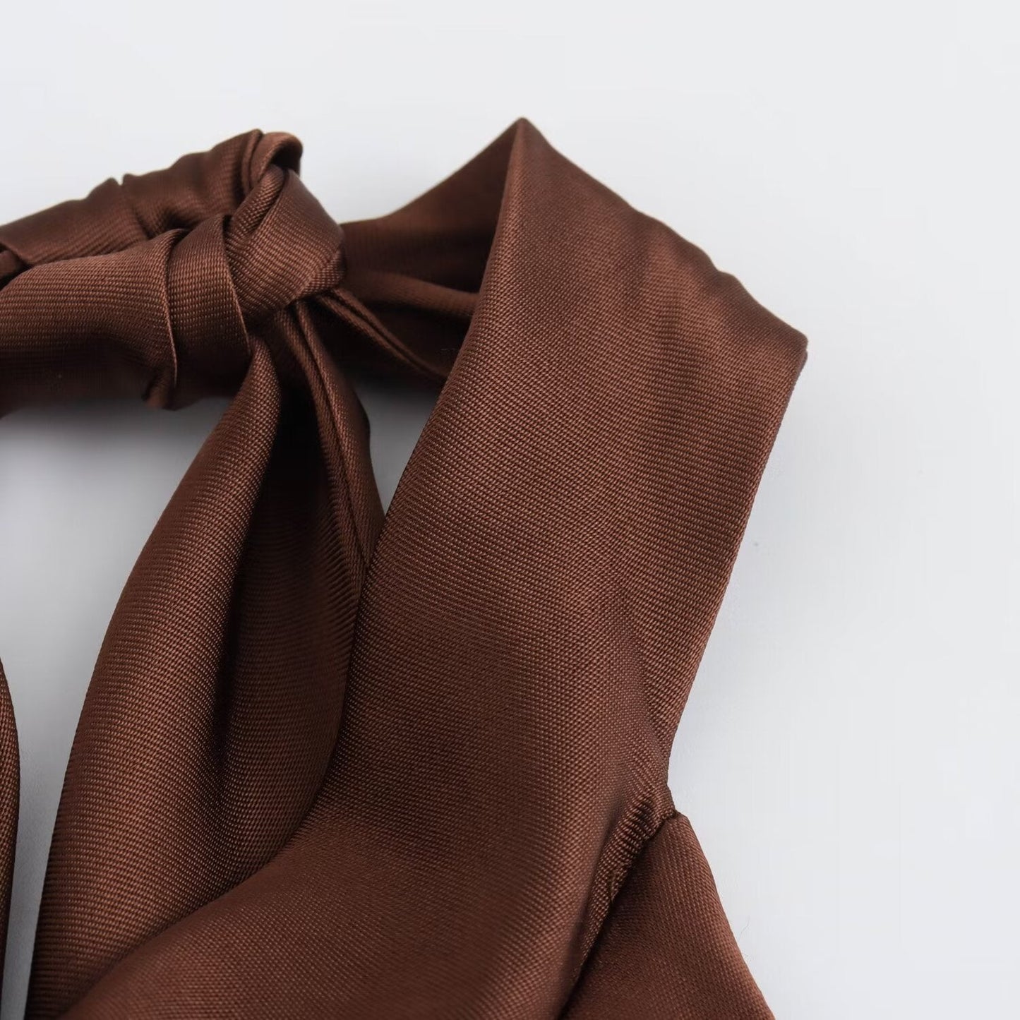 Close-up of the knotted brown satin halter strap on the Juniper open back maxi dress