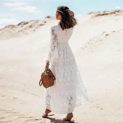 White Elodie lace long sleeve maxi dress seen from behind on a sandy beach