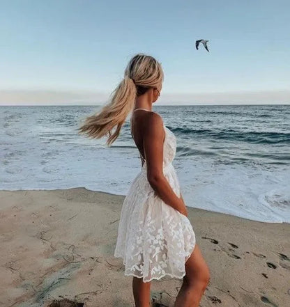 Back view of the white Elsie lace mini summer dress worn on the beach