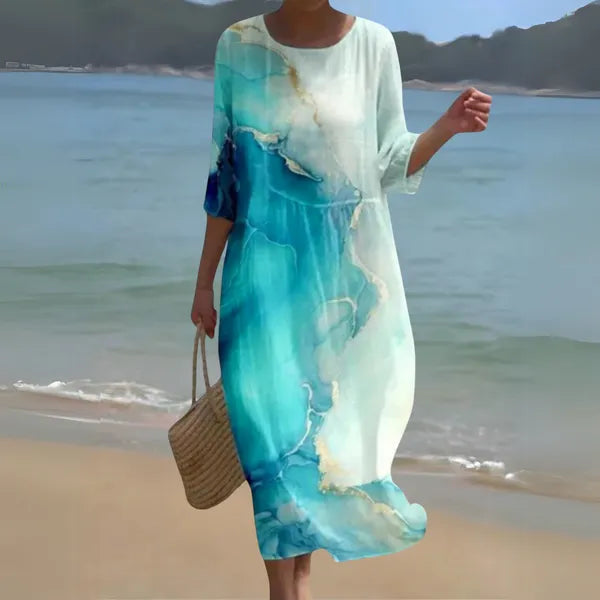Blue and white Kallie caftan maxi dress with marbled print, front view on the beach