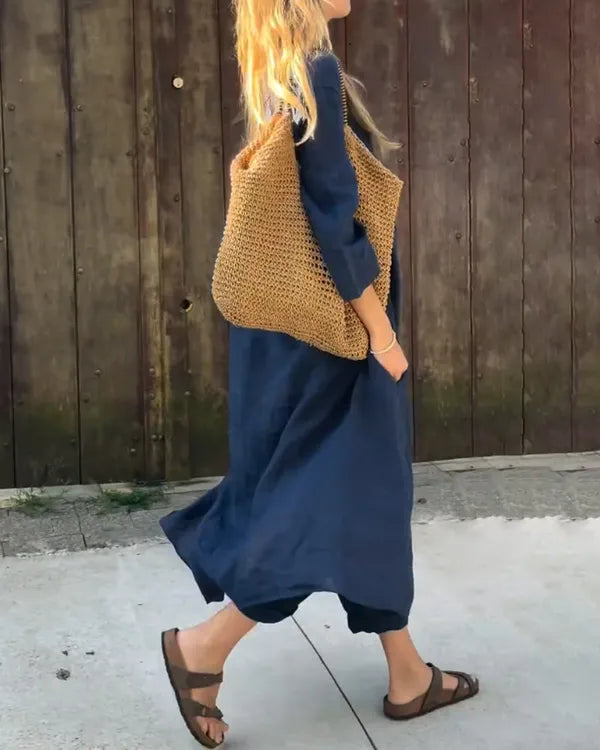 Fabiana navy blue two-piece linen set, side view of model walking outdoors
