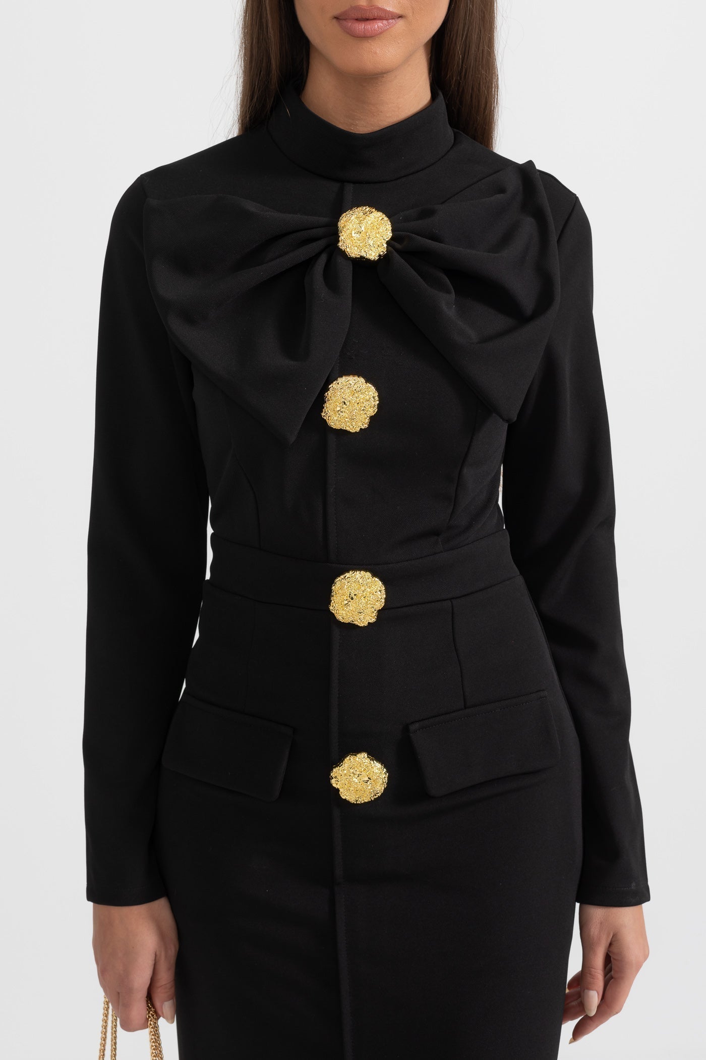 Close-up of the black Mireille midi dress bow collar and gold flower buttons