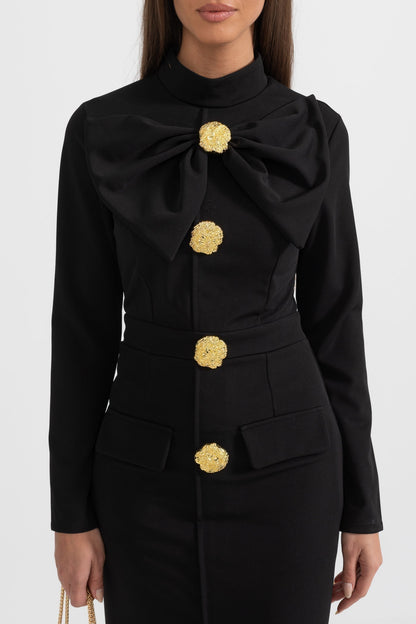 Close-up of the black Mireille midi dress bow collar and gold flower buttons