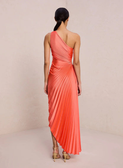 Rear view of the orange red Inka pleated maxi dress with asymmetric hemline