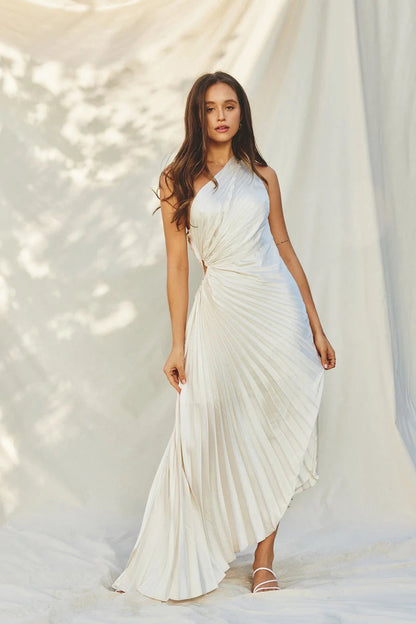Inka white one-shoulder pleated maxi dress, front view against draped fabric
