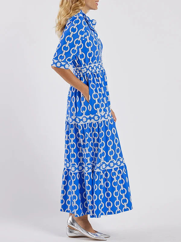Side profile of the blue Ninon print blouson tiered maxi dress on model