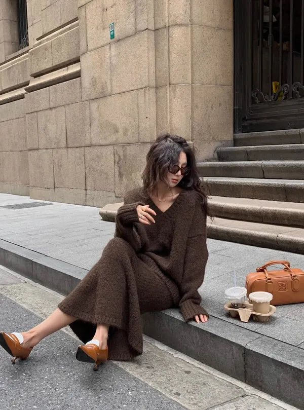 Janette brown knit sweater and skirt set, model seated on steps side view