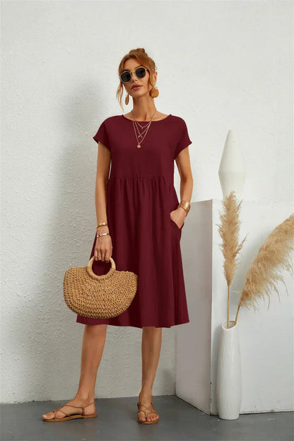 Henrietta women's shift summer midi dress in burgundy, front view with straw bag