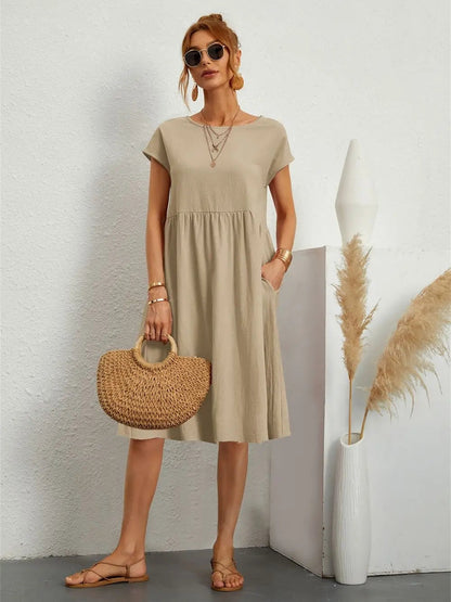 Henrietta women's shift summer midi dress in khaki, front view on model with straw bag