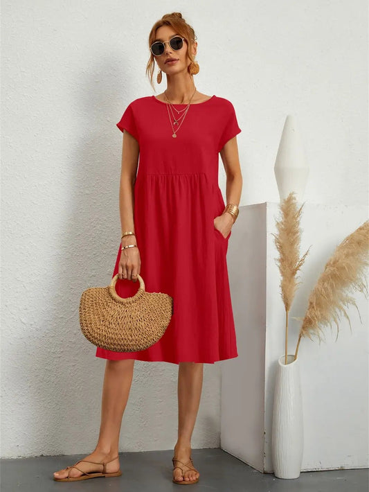 Henrietta women's shift summer midi dress in red, front view on model with straw bag