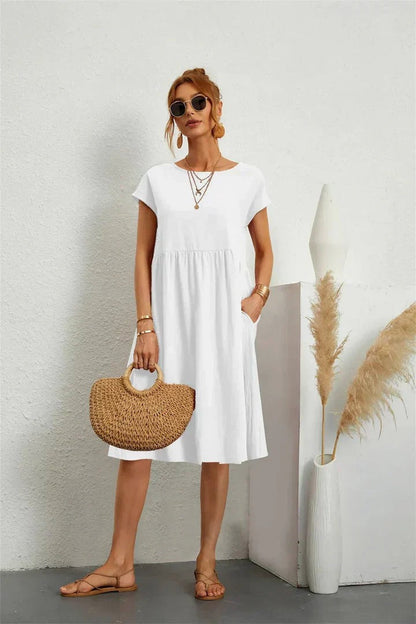 Henrietta women's shift summer midi dress in white, front view on model with straw bag
