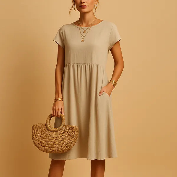 Beige Short Sleeve Babydoll Dress front view with straw bag and round neckline