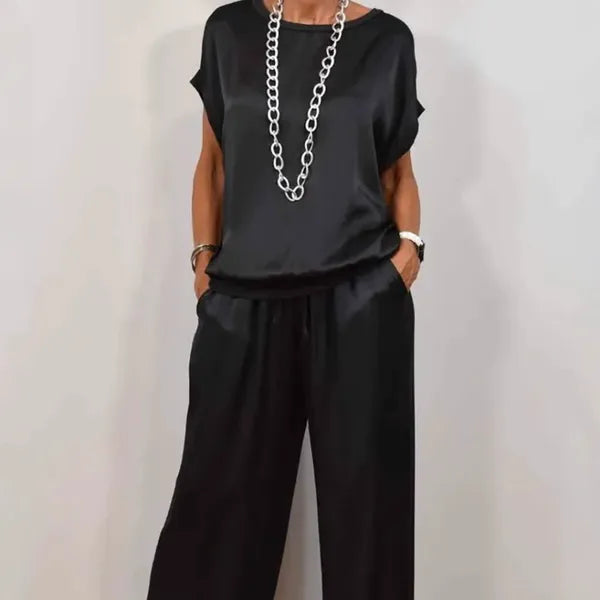 Anamaria black satin two-piece set, cropped front view with chain necklace