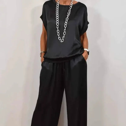 Anamaria black satin two-piece set, cropped front view with chain necklace