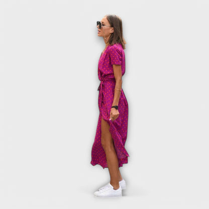 Mariz women's pleated midi dress in pink dot print, side view showing front slit