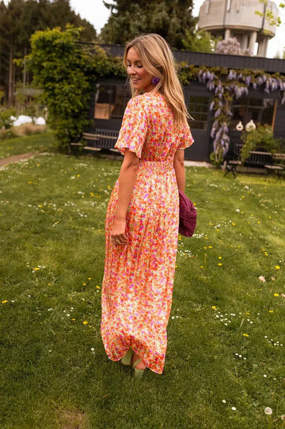 Back view of the orange Lotte short sleeves floral maxi dress on model