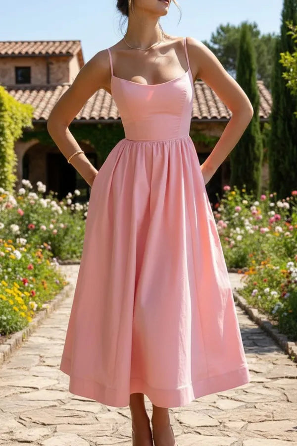 Mandy women's sleeveless cocktail midi dress in pink, front view in a garden