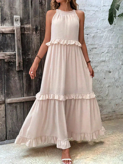 Kiersten beige sleeveless maxi dress front view against a rustic wooden door
