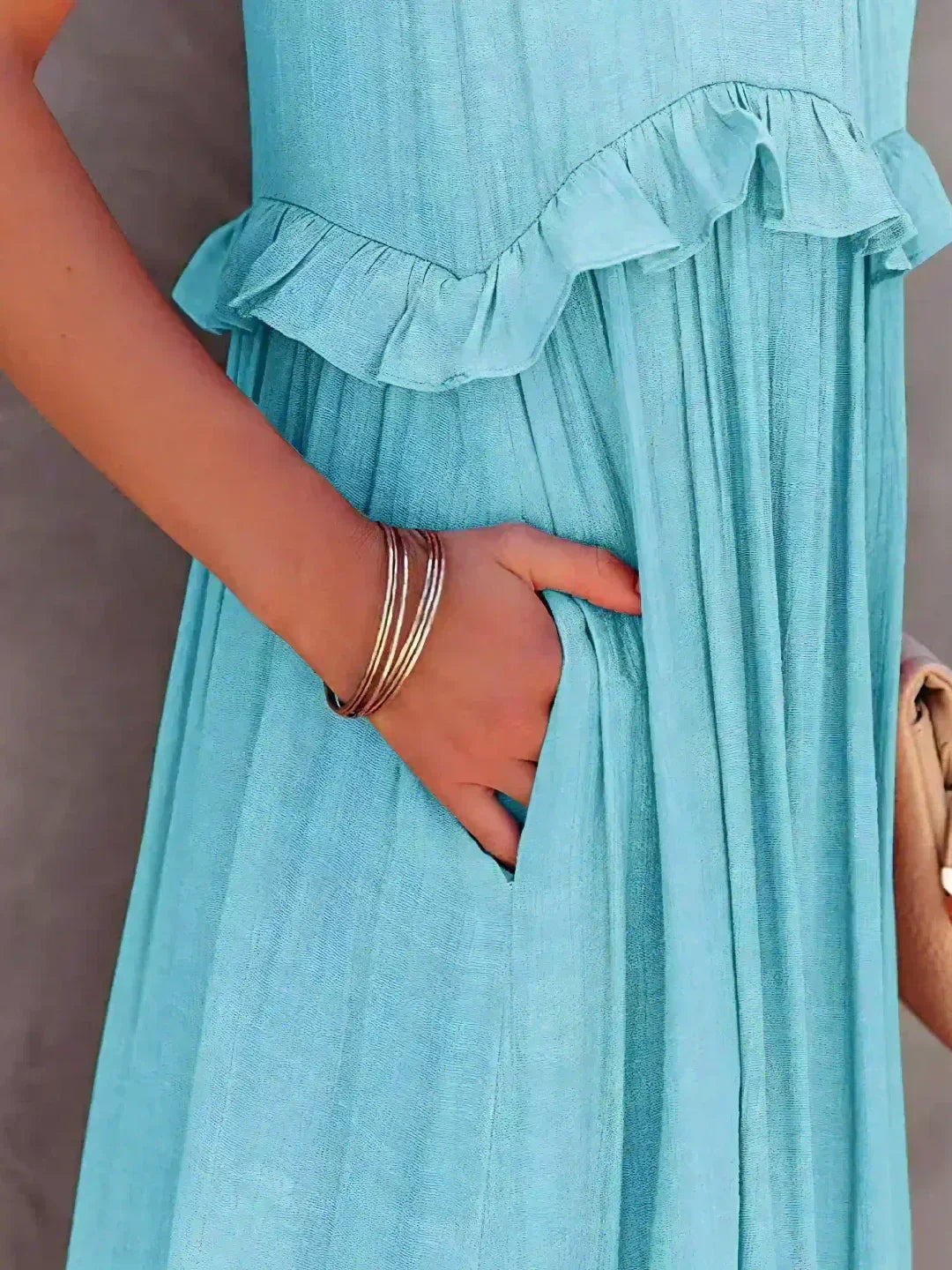 Close-up of the sky blue Kiersten maxi dress pocket and ruffle waist seam