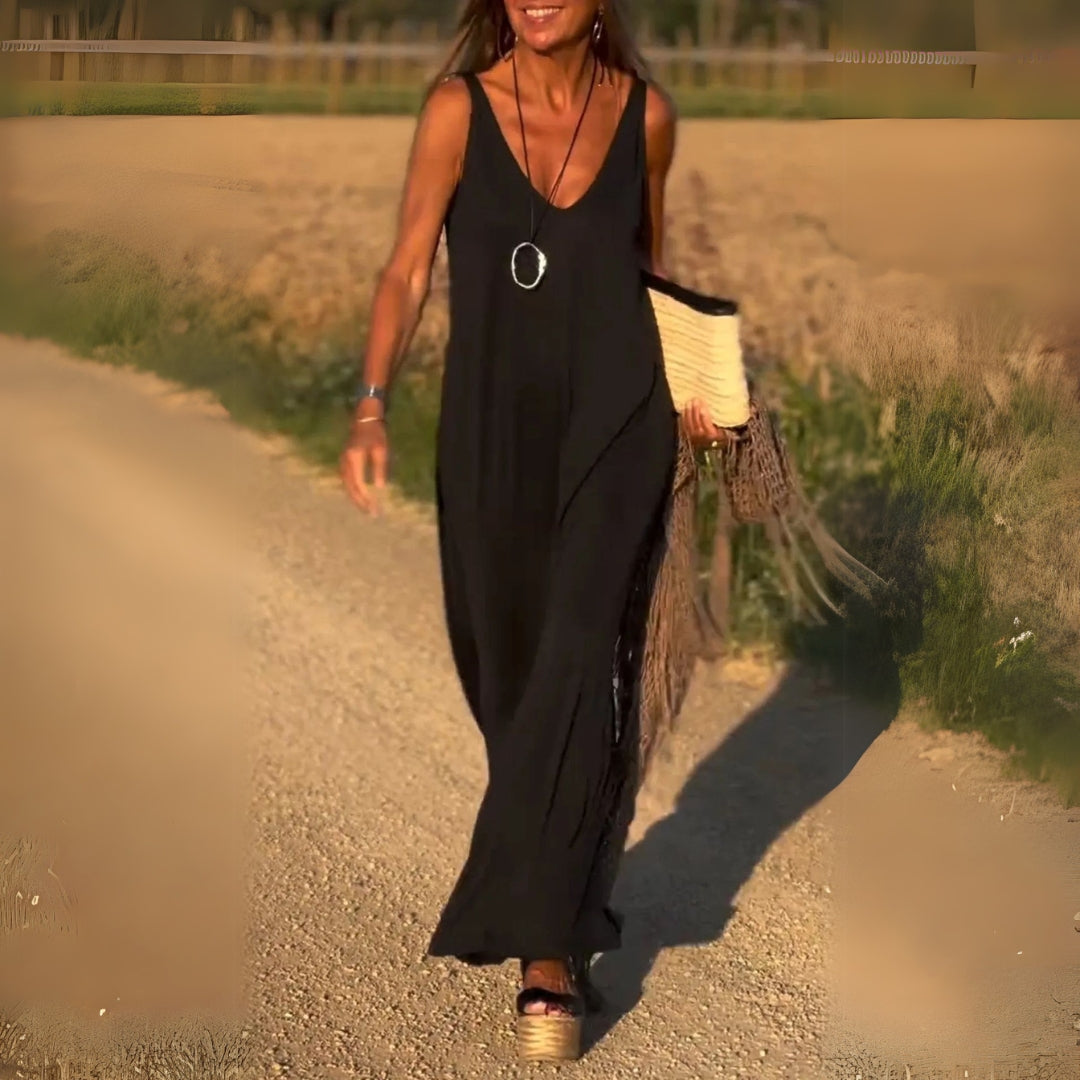 Black Kalina sleeveless V-neck maxi dress with side slit, front view on a country road