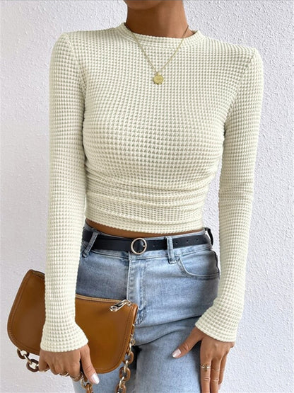 Danae Women's Textured Long Sleeve Crop Top in apricot cream, front view with jeans