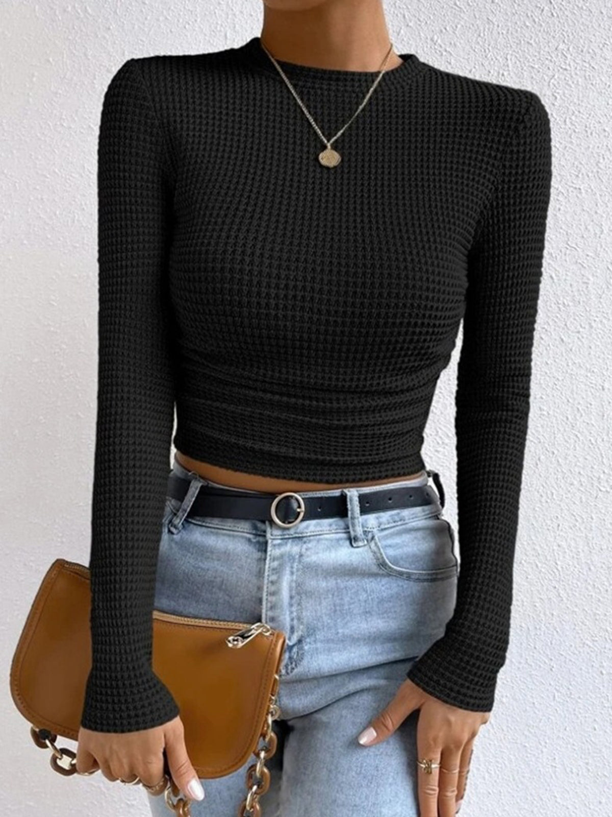Danae Women's Textured Long Sleeve Crop Top in black, front view with belted jeans