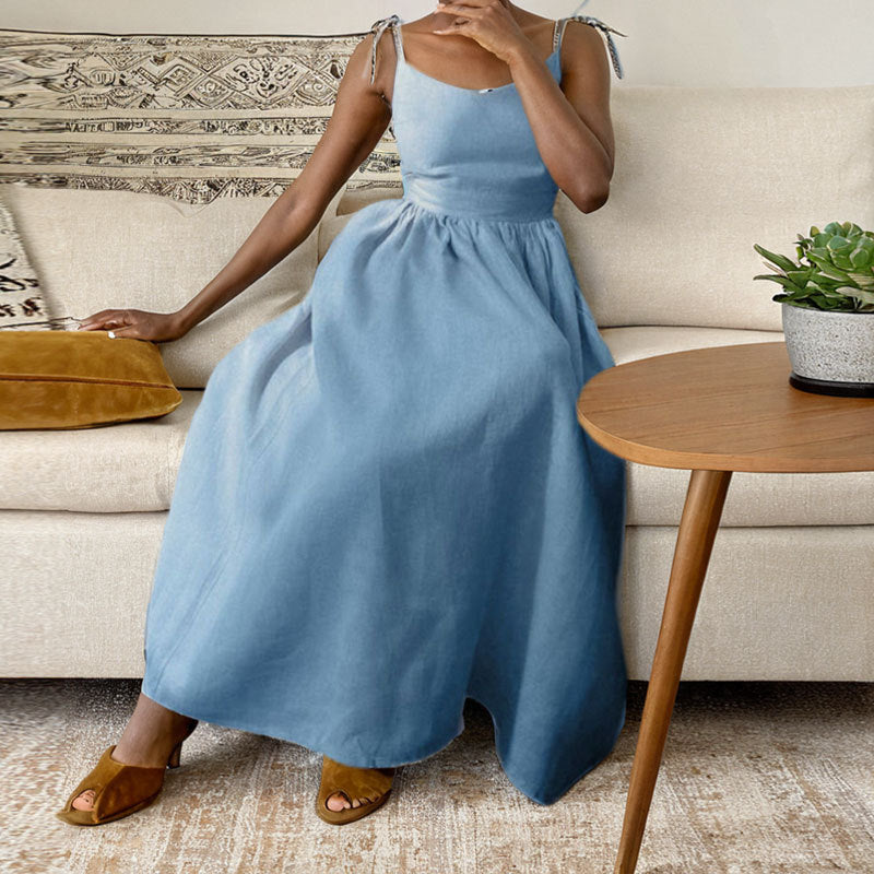 Eudora tie-strap maxi dress in sky blue linen, seated front view with sandals