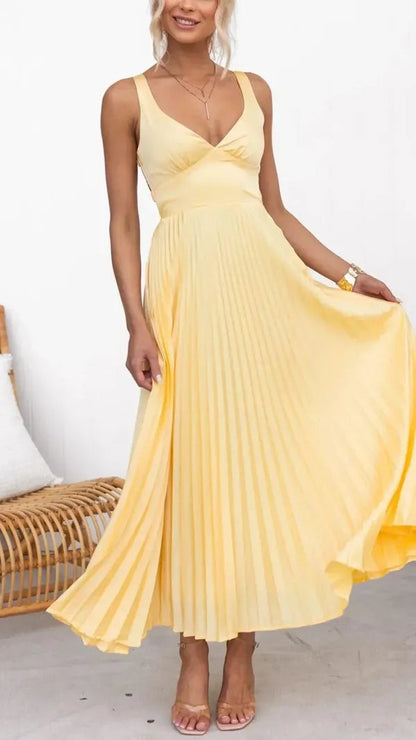 Aveline women's V-neck pleated maxi dress in yellow, model holding out the skirt