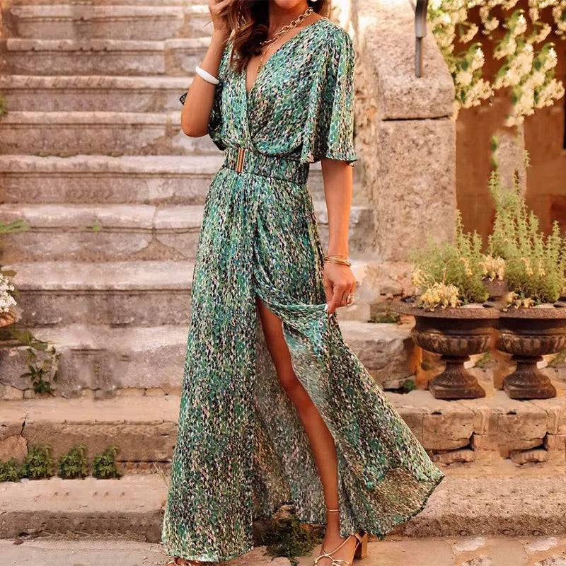 Green Olwen women's V-neck wrap maxi dress, front view with high slit on stone steps