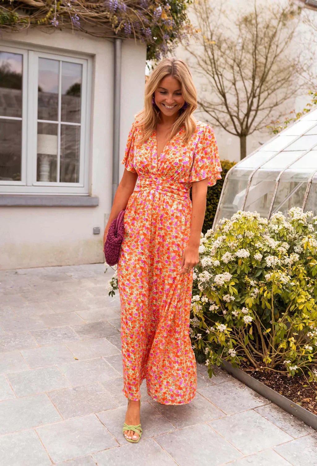 Orange Honoria women's floral wrap summer maxi dress, front styling shot outdoors