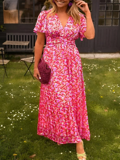 Pink Honoria women's floral wrap summer maxi dress, front view on model in garden
