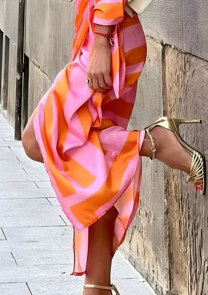 Close-up of the orange Sassa wrap midi dress skirt hem and side slit with heels