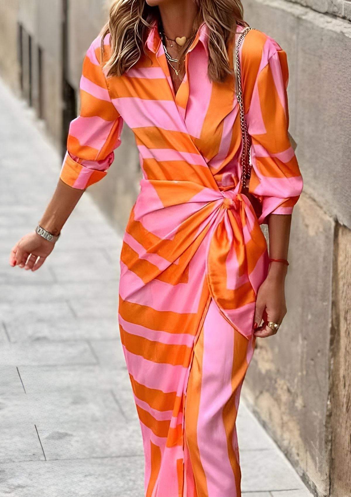 Full front view of the orange Sassa wrap midi dress worn on a city street